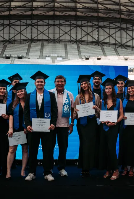 Étudiants de l’ECS Marseille en tenue de cérémonie montrant leur diplôme 2025